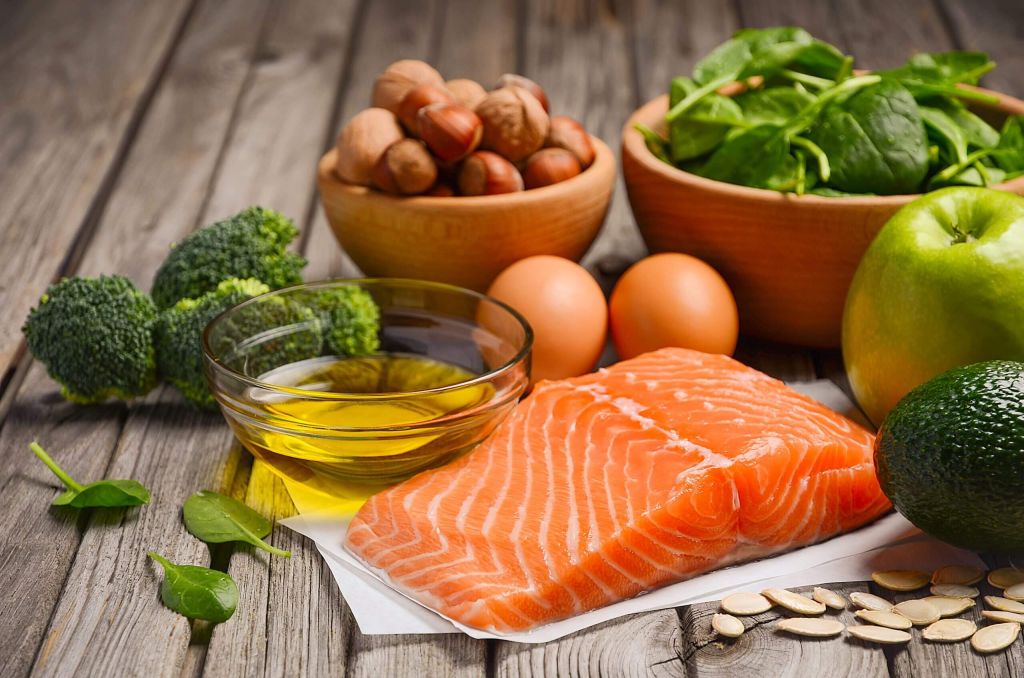 salmon, eggs, nuts, and greens sitting on a table