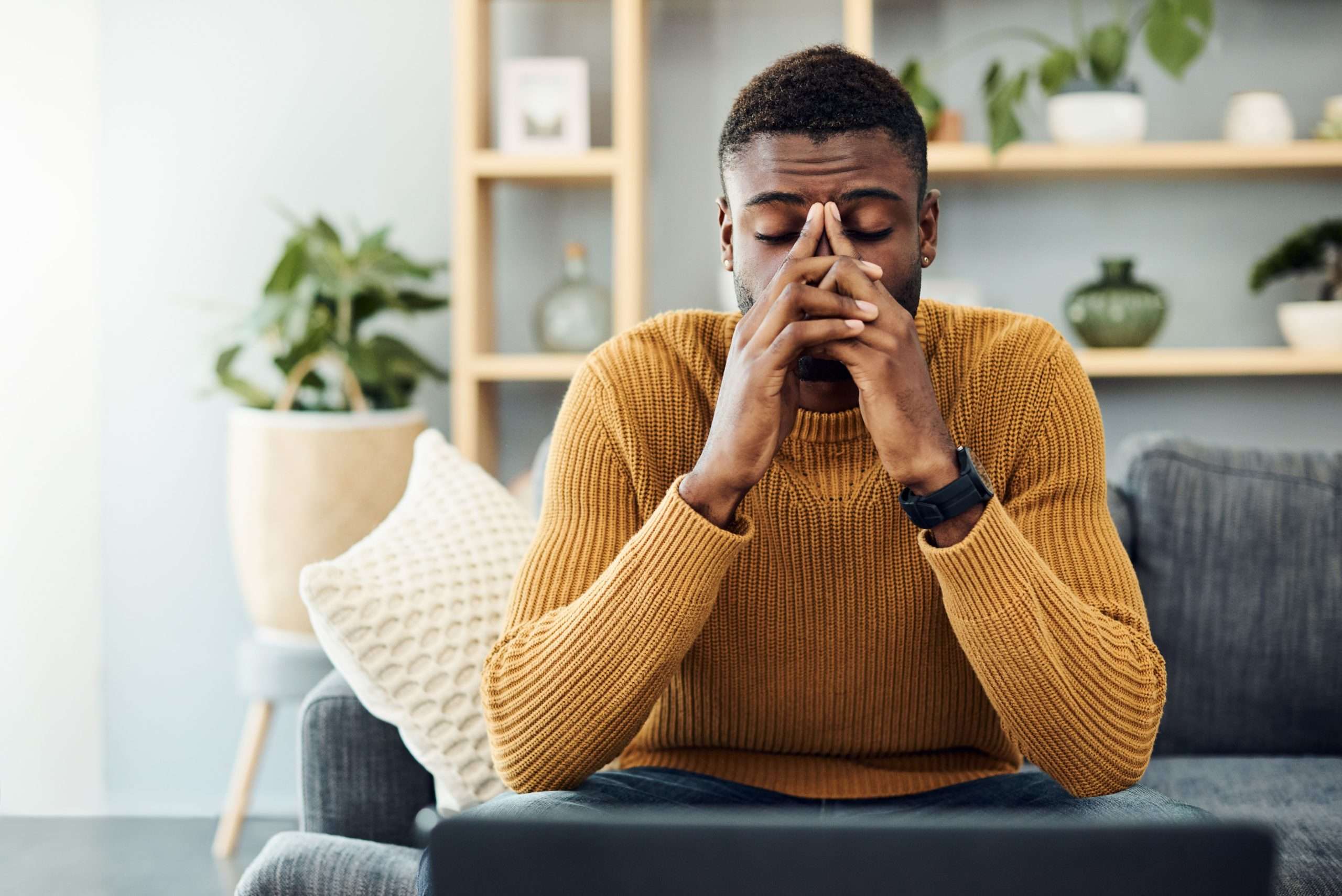 man looking worried with hands over face