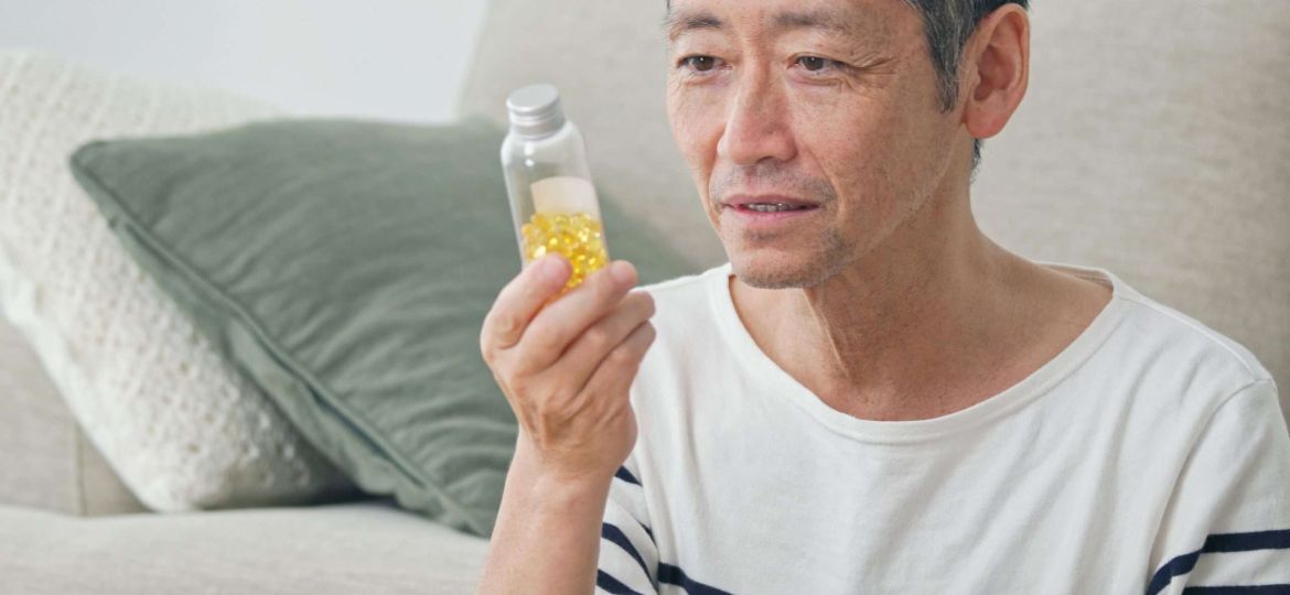 man holding bottle of supplements