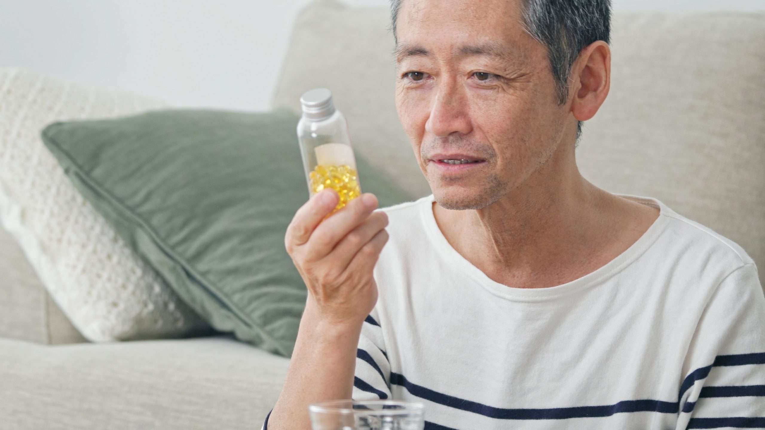 man holding bottle of supplements