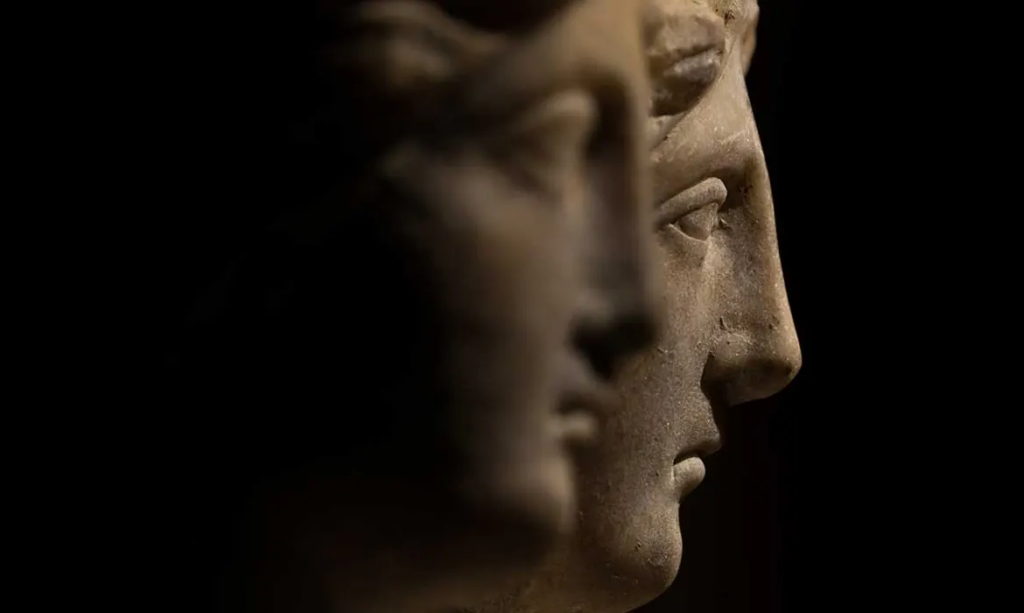 Brief History of Hair Identity, Self Expression, and the Impact of Hair Loss - the faces of two ancient statues looking to the right on a black background.