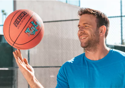 HairClub - Xtrands - Real Hair - a man with natural-looking hair outside spinning a basketball on his finger