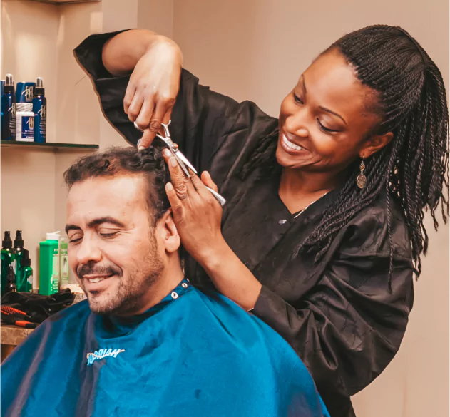 HairClub - Solutions 45 Years of Results - a professional HairClub stylist cutting and styling a client's hair.