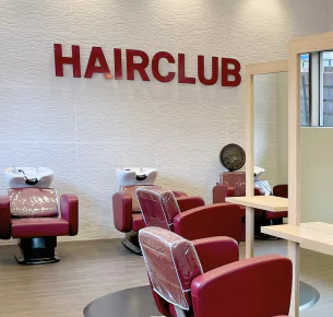 HairClub - Over 100 Locations - a salon at a HairClub Center - the HairClub logo is hanging on the wall.