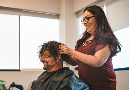 HairClub - Get a Solution Tailored to You - a professional HairClub stylist cuts and styles a man's hair at a HairClub Center.