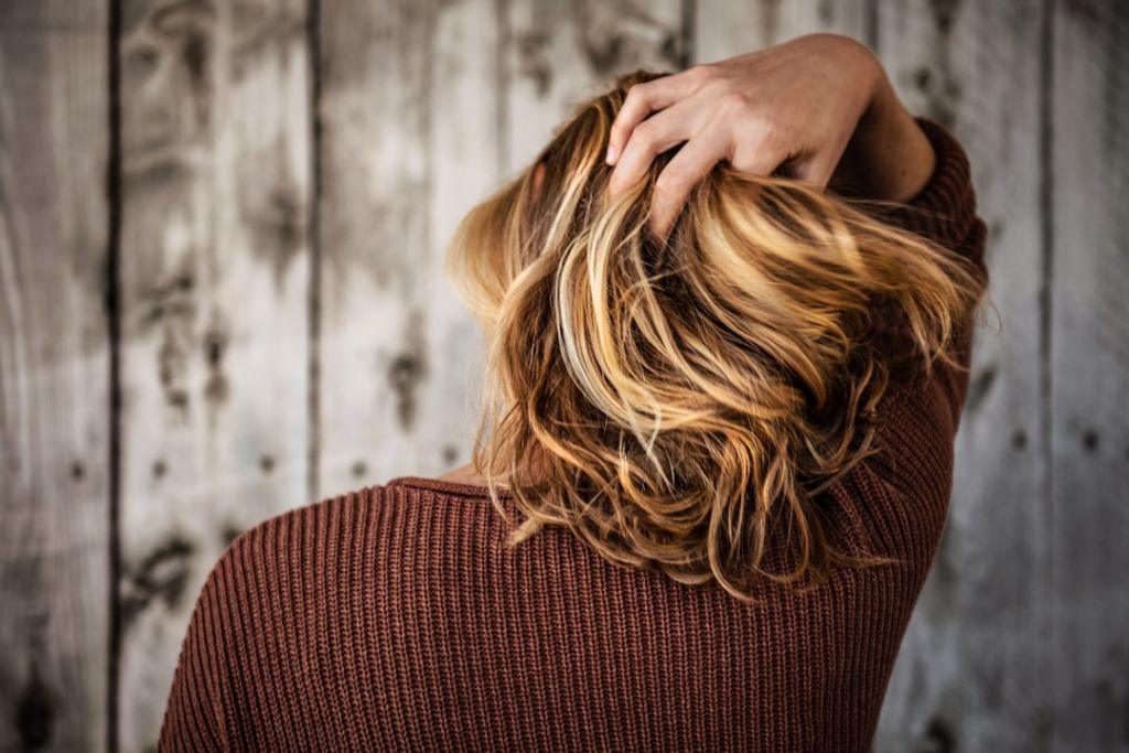hair growth improvements with hair club | image with girl raking her hands through new hair growth